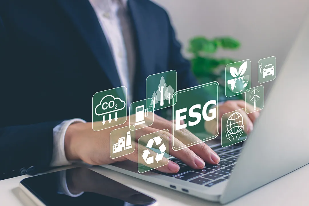 Professional using a laptop with ESG sustainability icons
